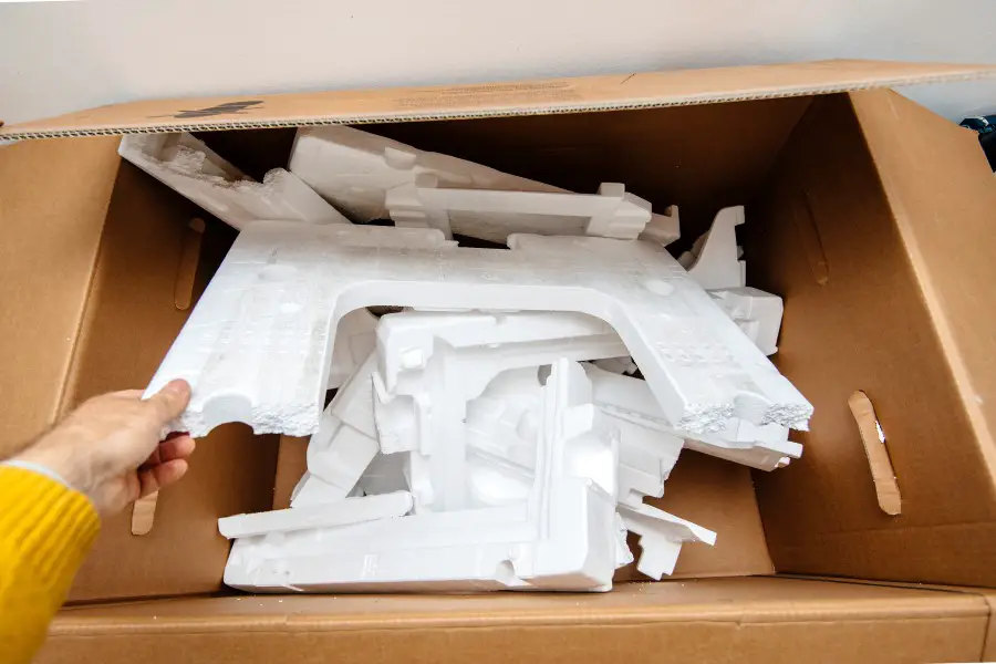 Man hand holding multiple waste inside cardboard containing Polystyrene the synthetic aromatic hydrocarbon polymer made from the monomer known as styrene